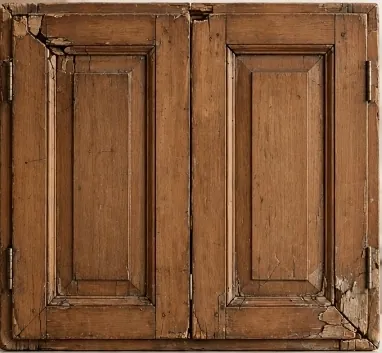 An old wooden cabinet door cracked and split at its corner joints